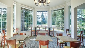 A dining area with a patterned floor, wooden chairs, and tables. - Best Western Country Lane Inn (Juneau)