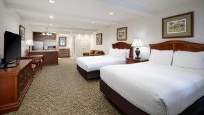 A hotel room with two beds, a desk, a television, and a kitchenette. - Best Western Country Lane Inn (Juneau)