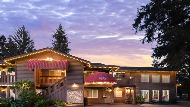 A two-story building with a red awning labeled "Lobby" and multiple windows. - Best Western Country Lane Inn (Juneau)