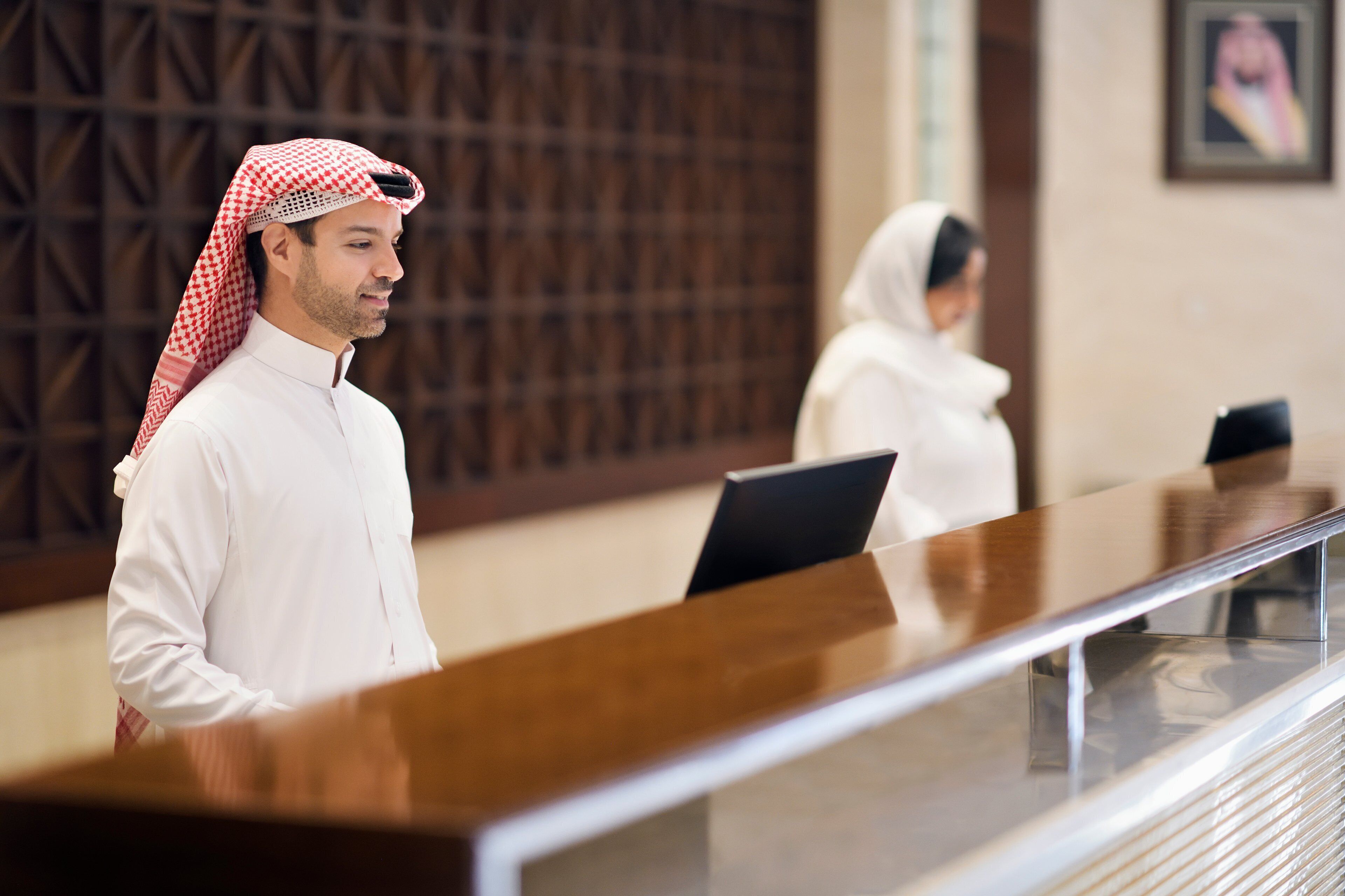 A reception desk with a man and a woman standing behind it.