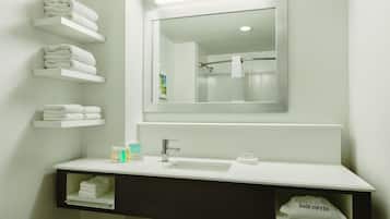 Un bagno con lavandino bianco, specchio e portasci.