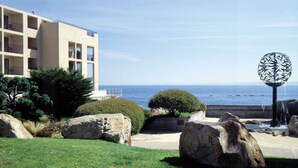 A modern building with multiple balconies overlooking a coastal view. - Monterey Bay Inn (Monterey)