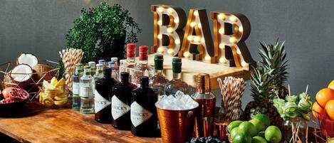 A bar setup with bottles, fruits, and a sign that reads "BAR".