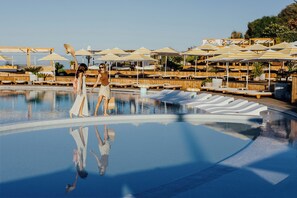Una piscina cubierta, una piscina al aire libre de temporada, sombrillas