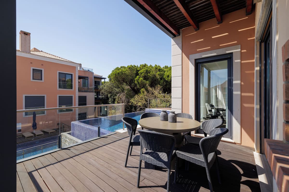 A balcony with a pool, outdoor seating, and a glass door leading to a terrace.