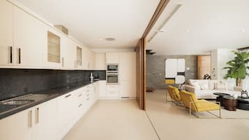 Een moderne keuken met witte kastjes, een zwart aanrecht en een inbouwoven.
