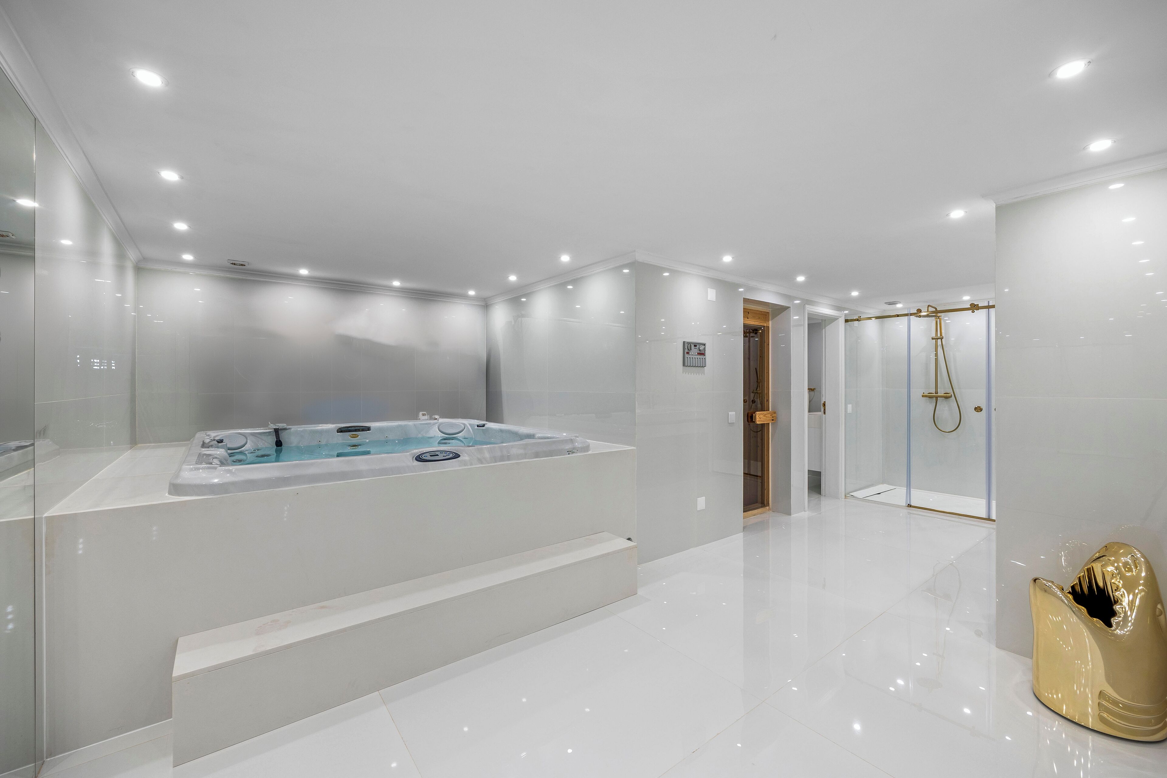 A modern bathroom with a large bathtub, a shower area, and a glass-enclosed toilet.