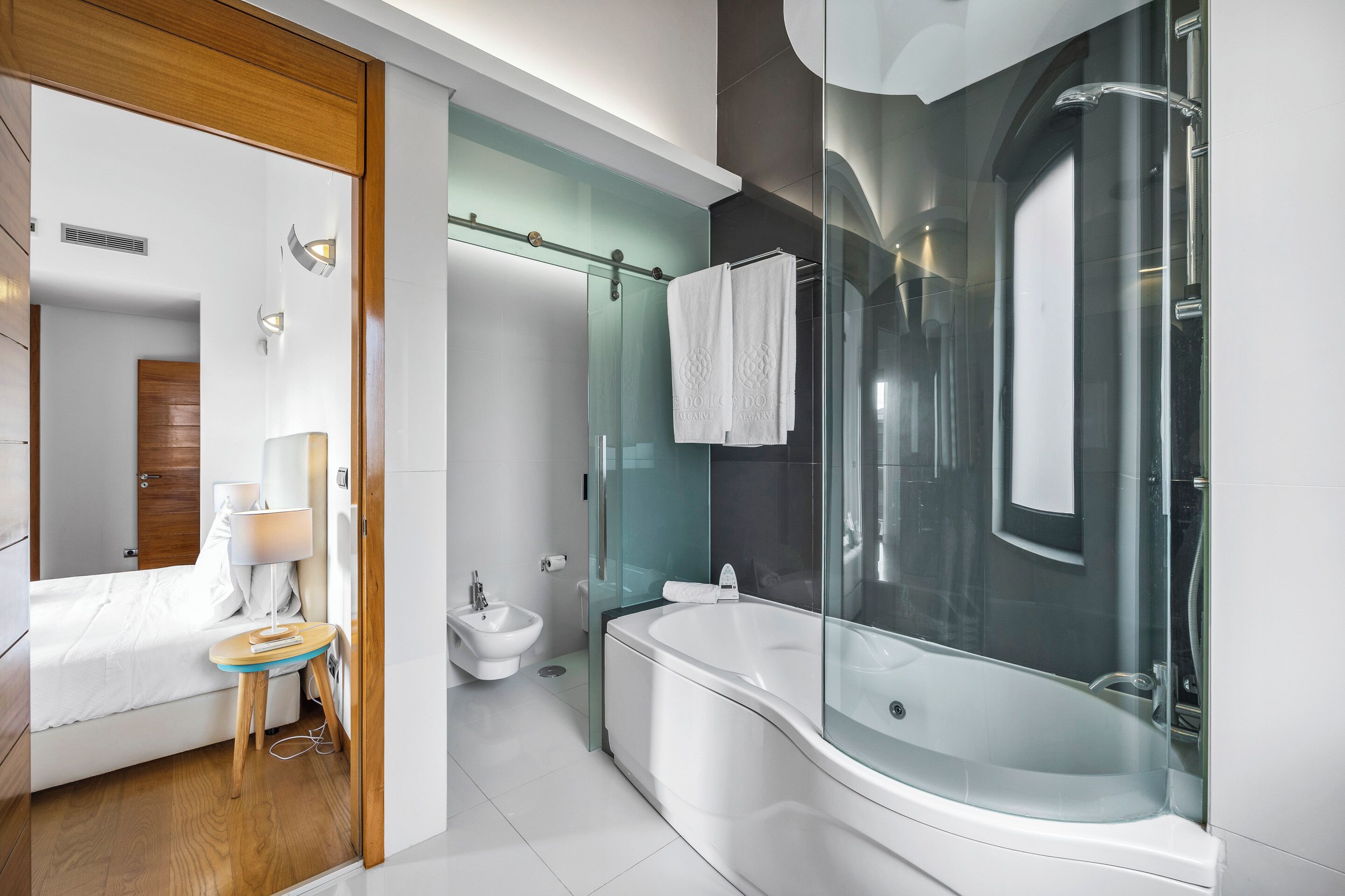 Un baño moderno con ducha envuelta en vidrio, una bañera independiente y un bidé.