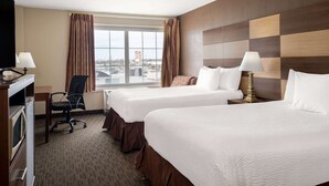A hotel room with two beds, a desk with a computer, a chair, and a window with curtains. - AmericInn by Wyndham Cedar Rapids North (Cedar Rapids)