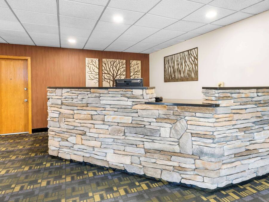 A reception area with a stone counter, a wooden door, and patterned carpet.