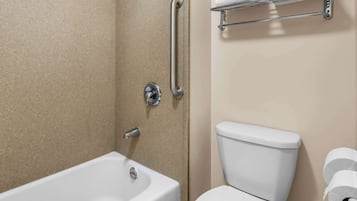 A bathroom with a bathtub, toilet, and a towel rack.