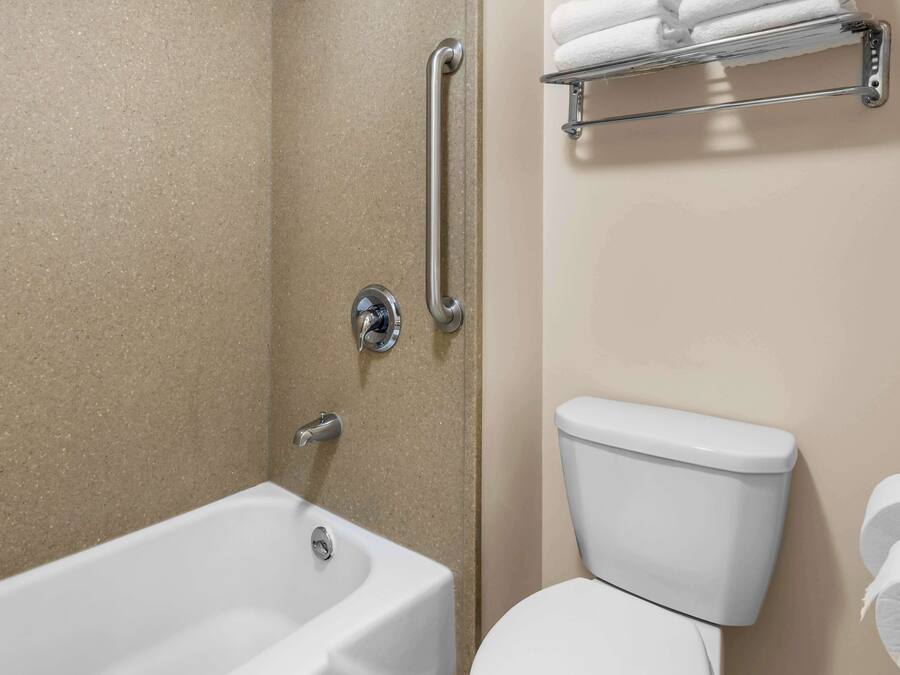 A bathroom with a bathtub, toilet, and a towel rack.