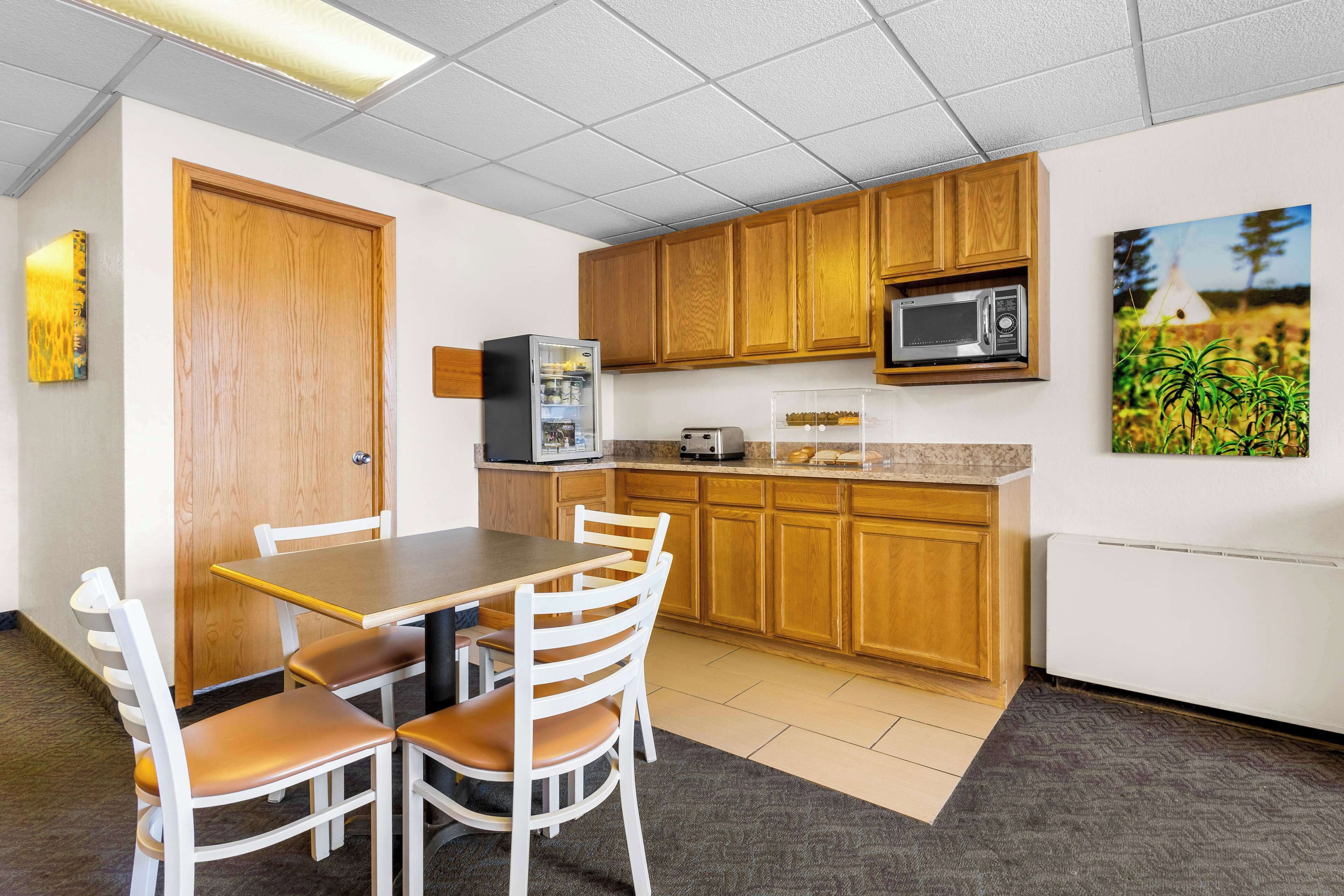 A compact kitchen with wooden cabinets, a microwave, a toaster, and a refrigerator.
