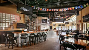 A bar area with a counter, stools, and a seating area with tables and chairs.