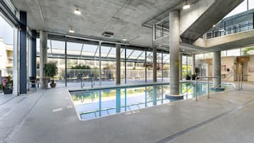 Una piscina techada, sillones reclinables de piscina