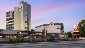 A hotel with a prominent 'Best Western Plus' sign, a large building with multiple floors, and a covered outdoor area with seating.