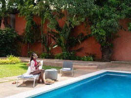 Una piscina al aire libre, sillones reclinables de piscina