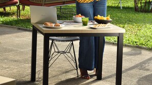 A person standing at an outdoor table with a laptop, a bowl of food, and a drink. - ibis Styles Abidjan Marcory (Abidjan)