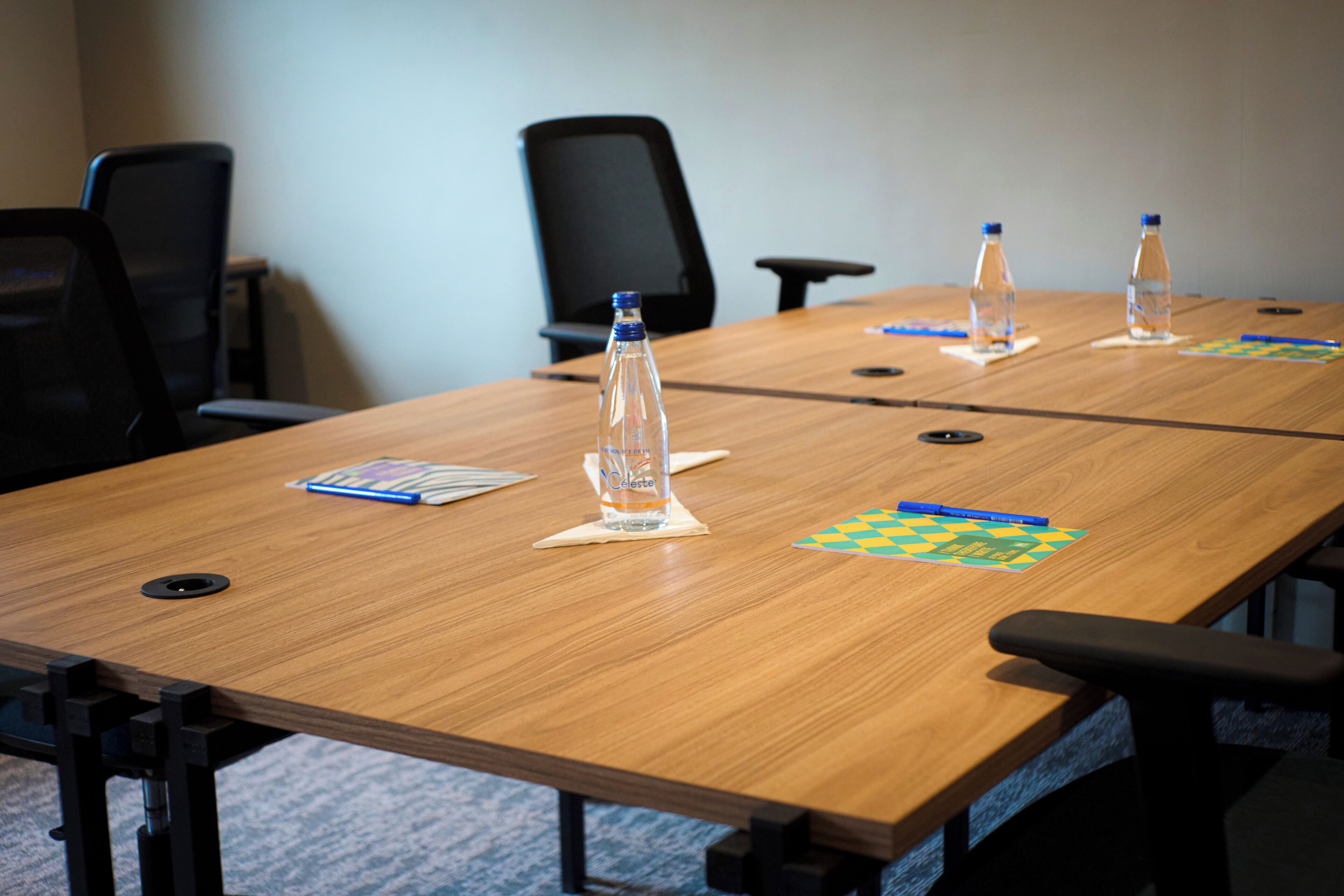 Une table de conférence avec des bouteilles d’eau, un jeu d’échecs et un bloc-notes.