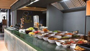 Un bufé con diversos alimentos y una máquina de café.