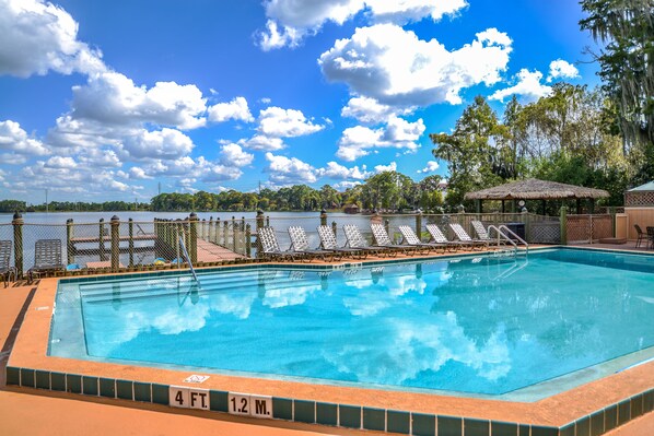 Una piscina al aire libre, sillones reclinables de piscina