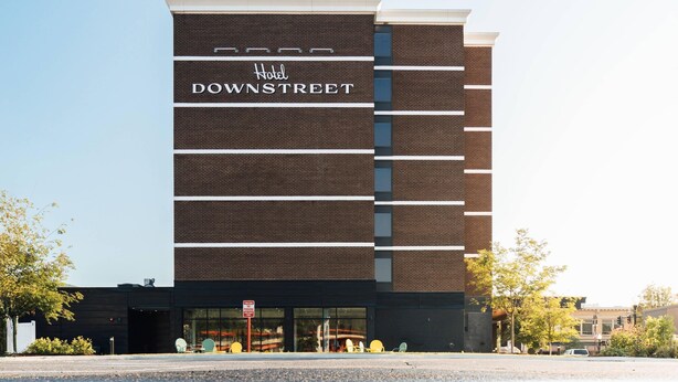 A modern hotel with a name sign 'Hotel Downstreet' on the facade.