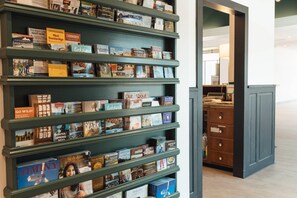 A bookshelf with various books and pamphlets, including titles like 'JIMINY' and 'Berkshire Landscapes'. - Hotel Downstreet, an Ascend Collection Hotel (North Adams)