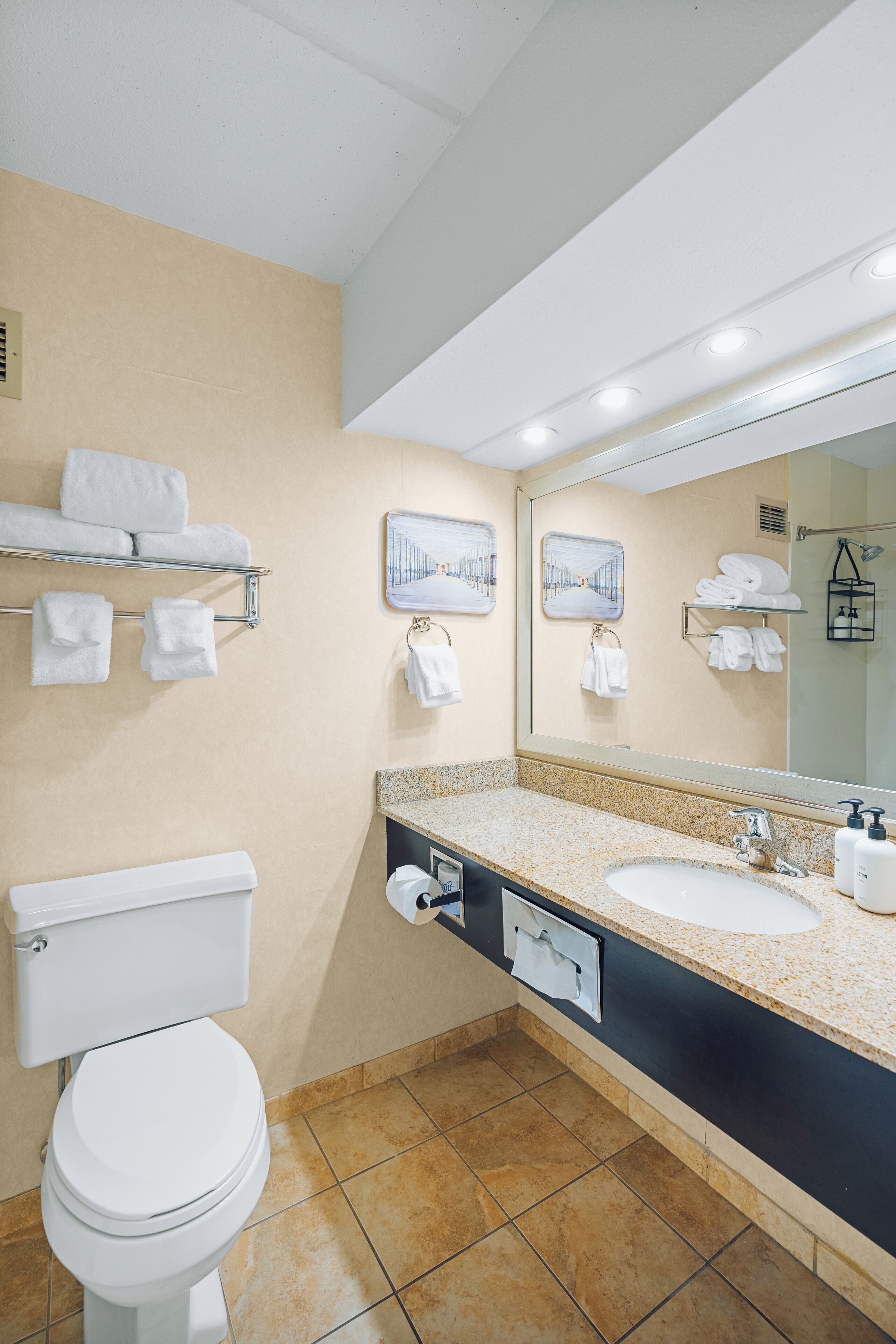 A modern bathroom with a toilet, sink, and towel rack.
