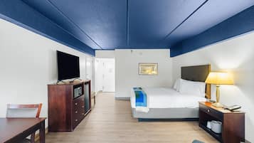 Une chambre d’hôtel équipée d’un lit, d’une table de chevet, d’une lampe, d’une télévision et de meubles en bois.