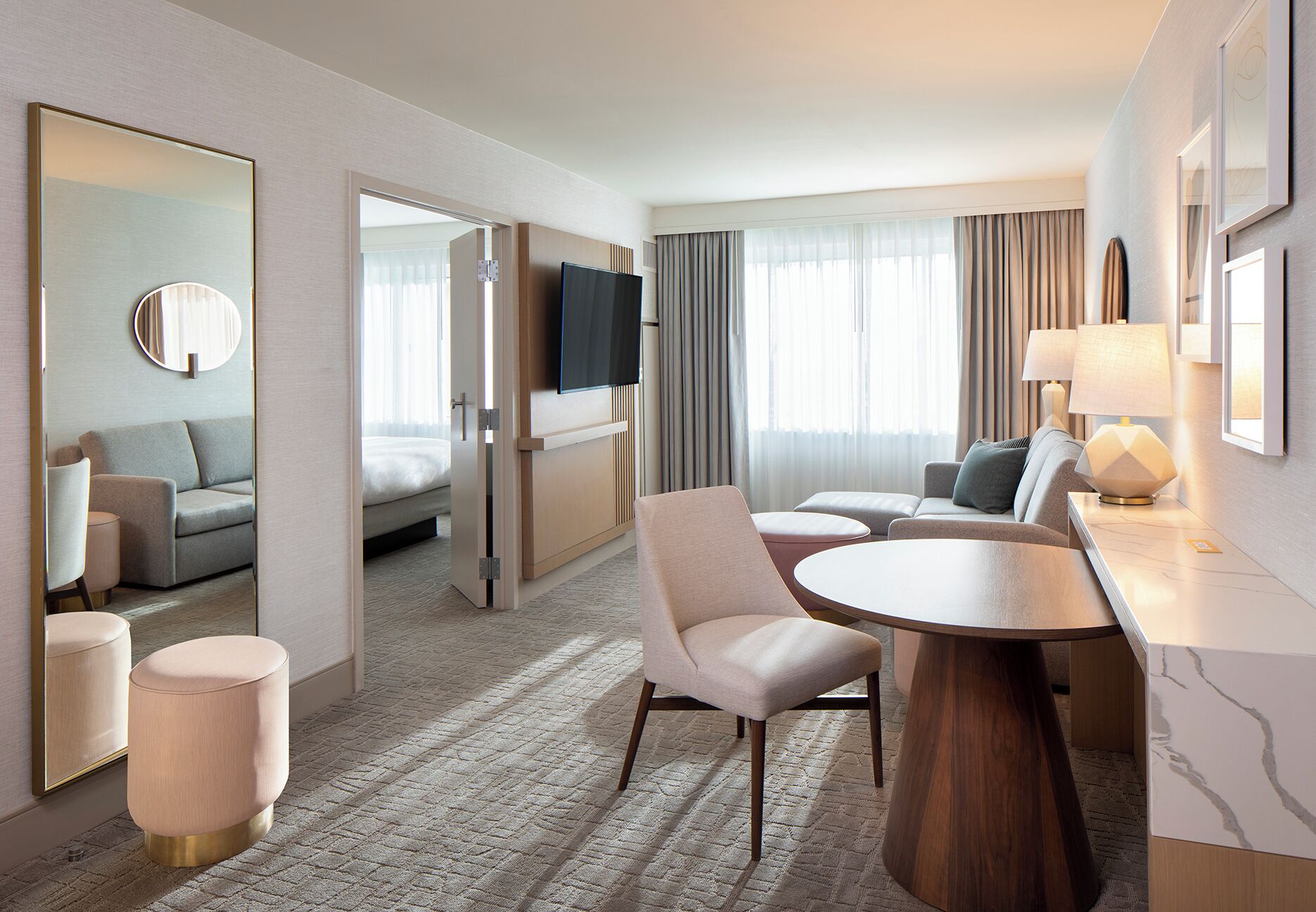 Una habitación de hotel con cama, sofá, mesa de comedor y televisor.