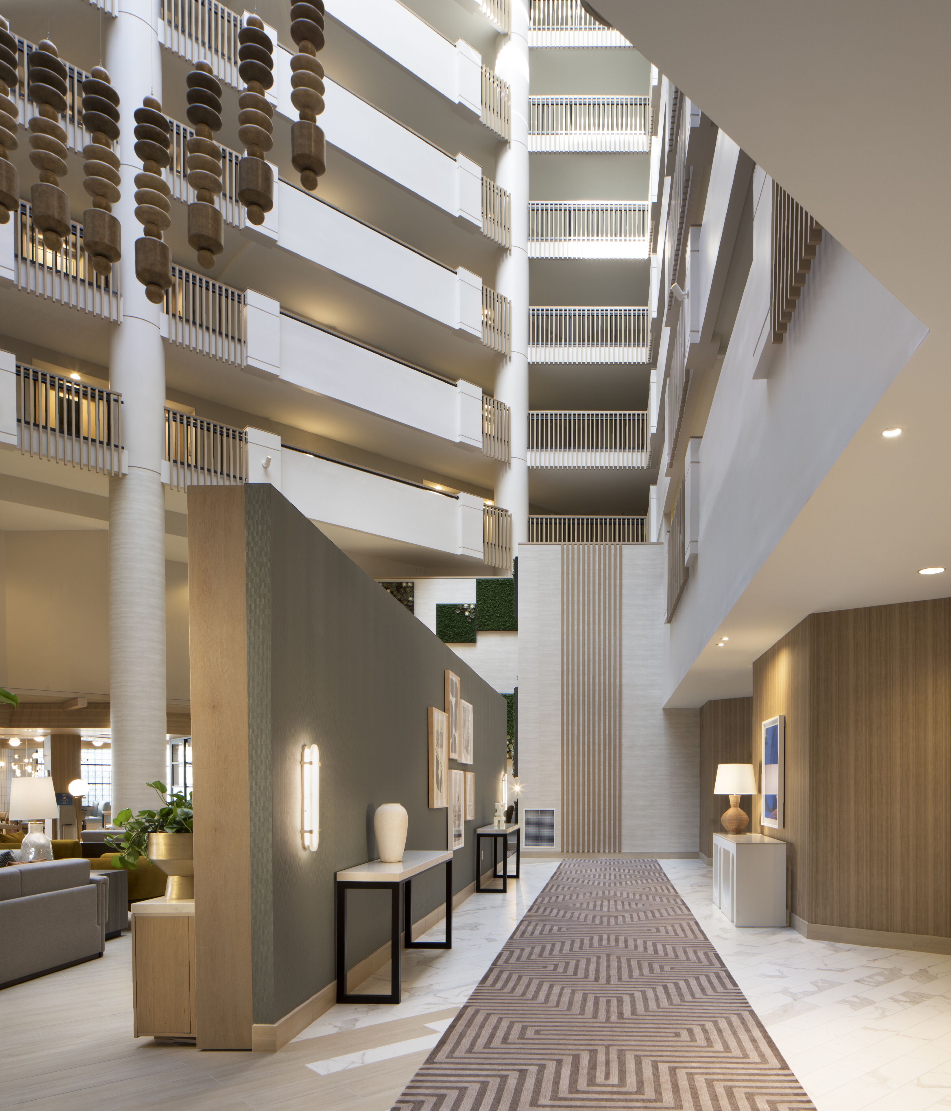 A multi-level atrium with a central staircase, modern furnishings, and a patterned carpet.