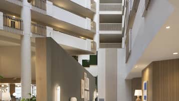 A multi-level atrium with a central staircase, modern furnishings, and a patterned carpet.