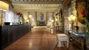 Un vestíbulo imponente con pared de piedra, chimenea y una larga recepción.
