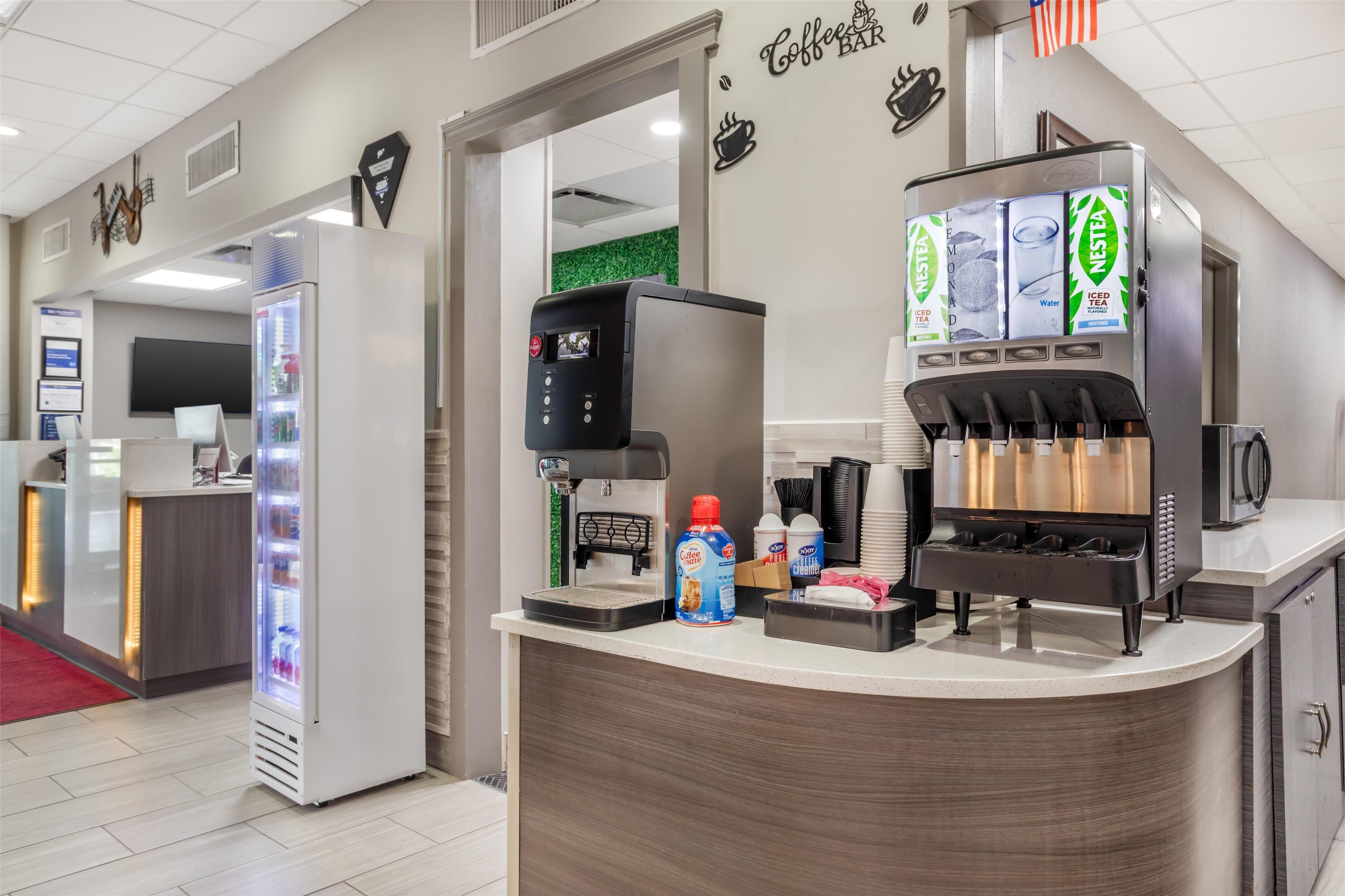 Un espace proposant du café, équipé d’une machine Nespresso, d’un réfrigérateur et d’un distributeur de café.