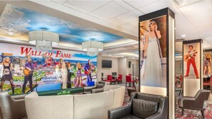 A hotel lobby with a 'Wall of Fame' featuring musicians, a large portrait of a woman in a dress, and comfortable seating areas. - Best Western Downtown Plus Music Row (Nashville)