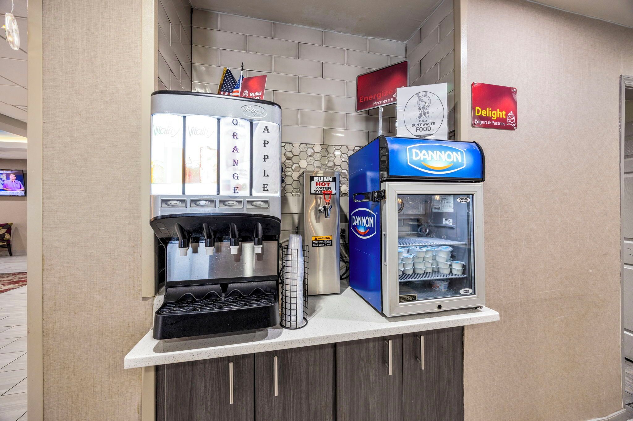 Een automaat met drankjes, inclusief een koffieapparaat, een waterkraan en een koelkast voor koude dranken.