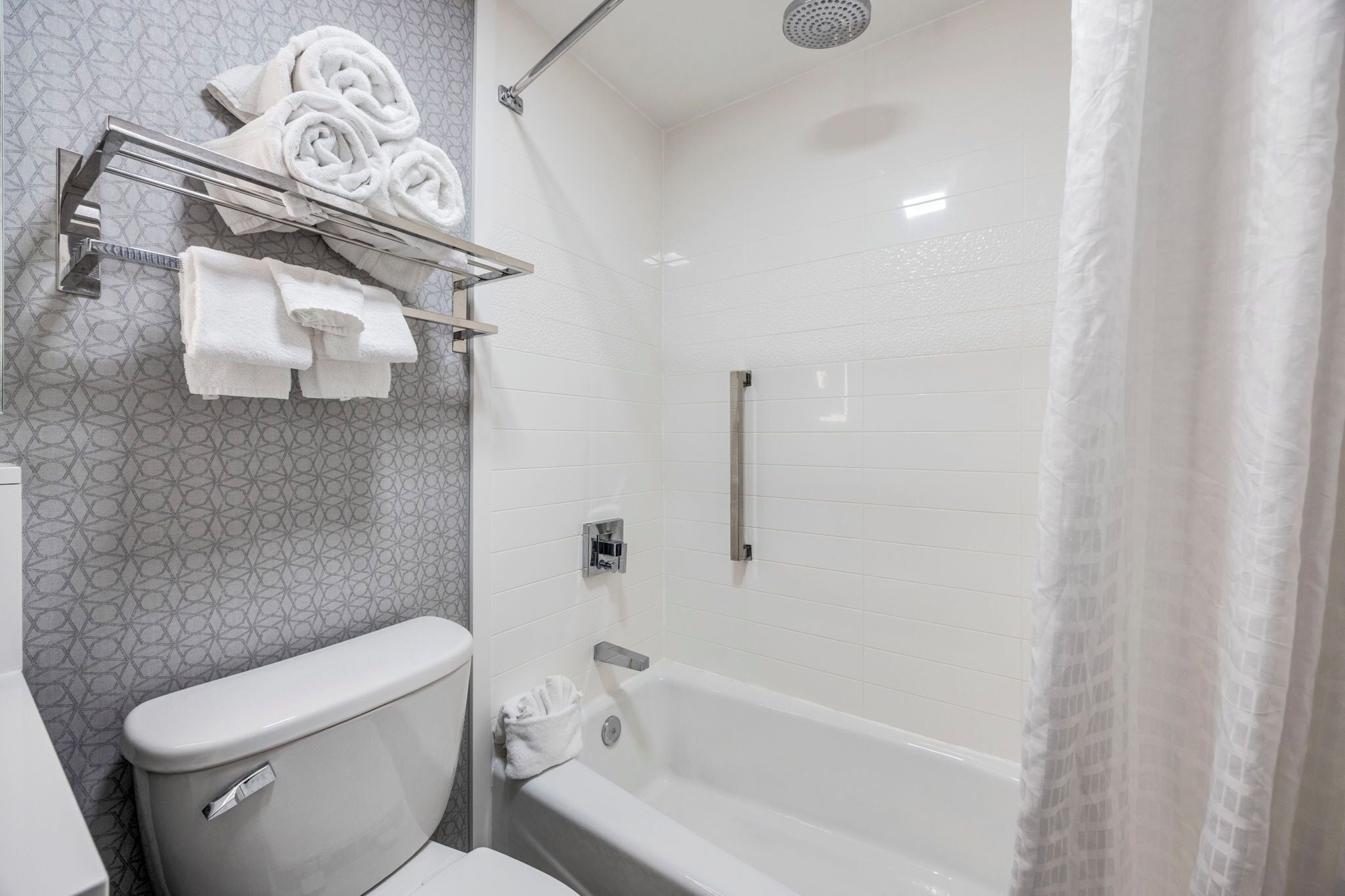 A bathroom with a toilet, a bathtub, and a shower area.