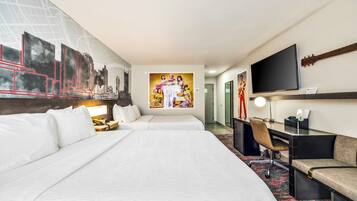 A hotel room with two beds, a desk, a chair, a television, and a large painting on the wall.