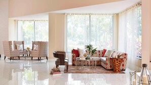 A spacious living room with a sofa, armchairs, and a coffee table. - Renaissance Orlando Airport Hotel by Marriott (Orlando)