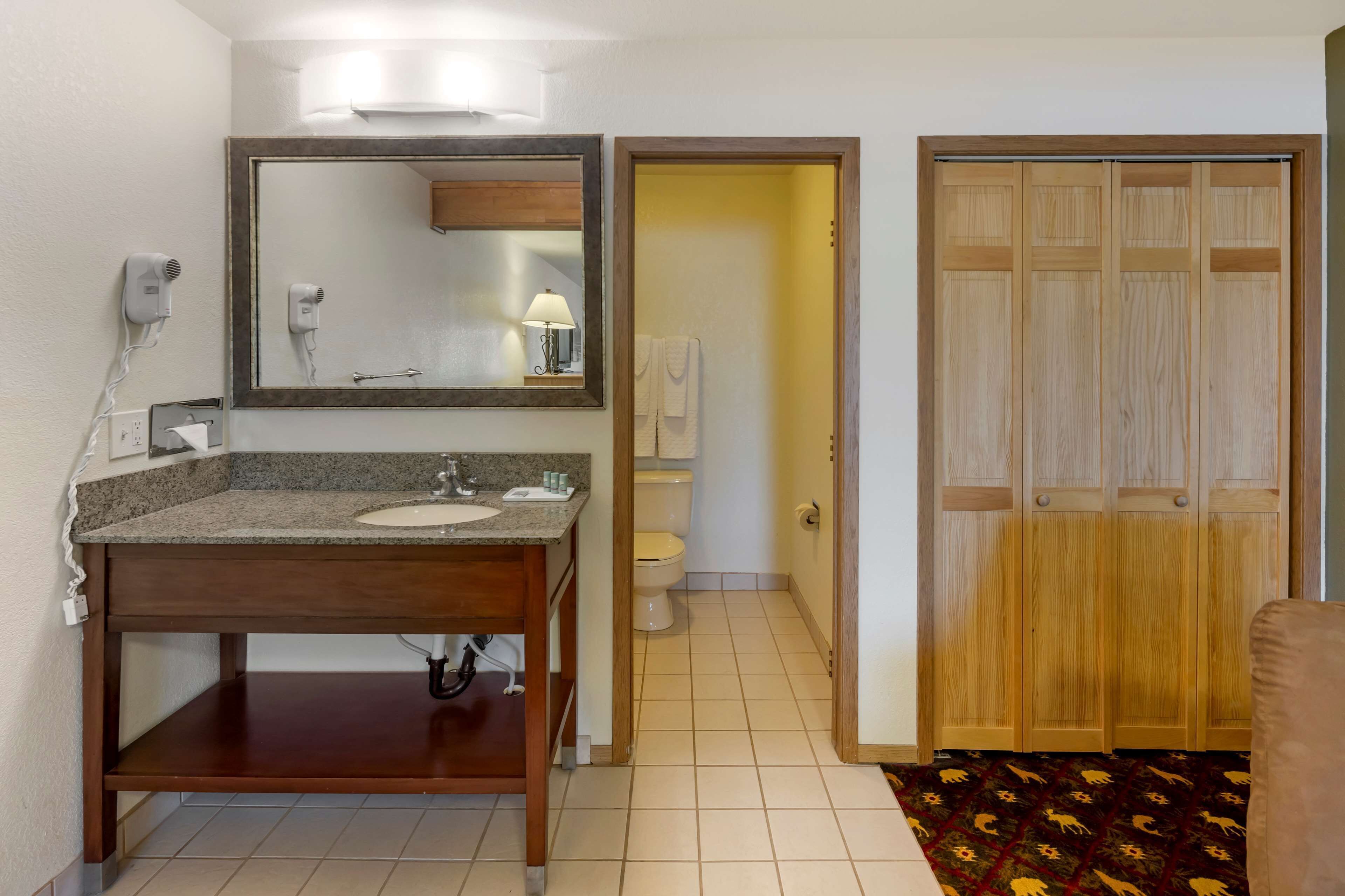 Ein Badezimmer mit Waschbecken, Spiegel und Toilette.