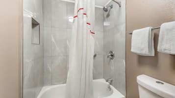 A bathroom with a shower, a bathtub, and a toilet.