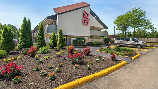 A Red Roof Inn with a modern design, landscaped garden, and a parking area.
