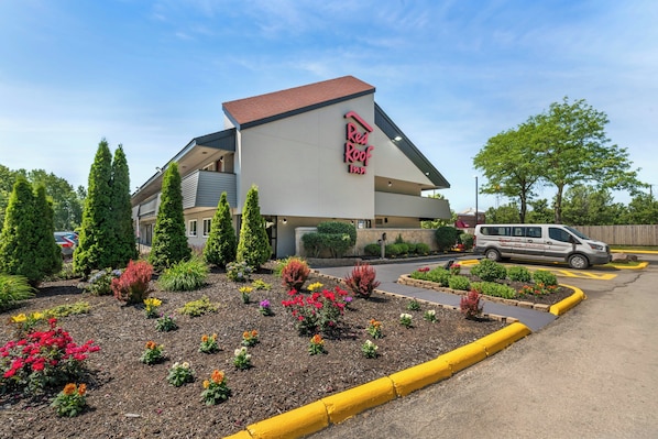 A Red Roof Inn with a modern design, landscaped garden, and a parking area.