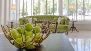 A green sofa in a bright room with large windows. - Luna Hotel Turismo (Abrantes)