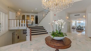 A grand lobby with a marble floor, a large chandelier, and a staircase leading to an upper level. - Luna Hotel Turismo (Abrantes)