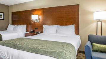 Une chambre d’hôtel avec un grand lit, un bureau avec une lampe et une chaise.