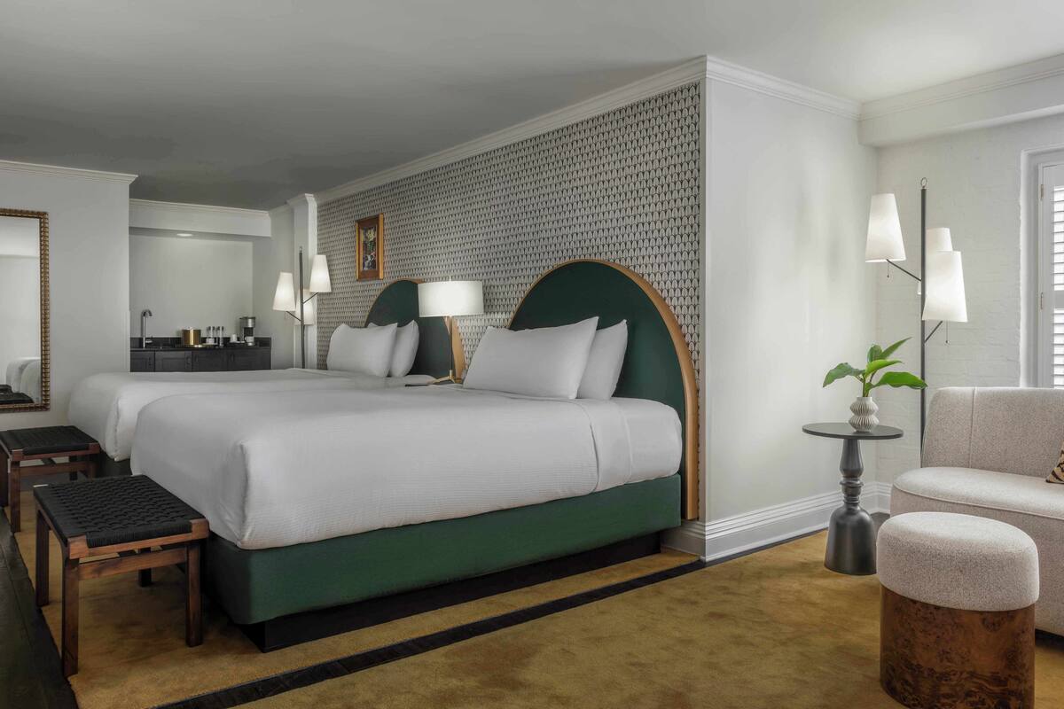 Een hotelkamer met een groot bed, een bank, een bureau en een kleine tafel.
