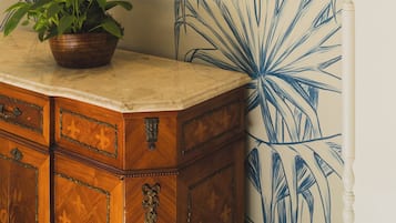 Ein Badezimmer mit einem großen Spiegel, einer Holzausstattung und einem Wanddesign mit Blumenmuster.