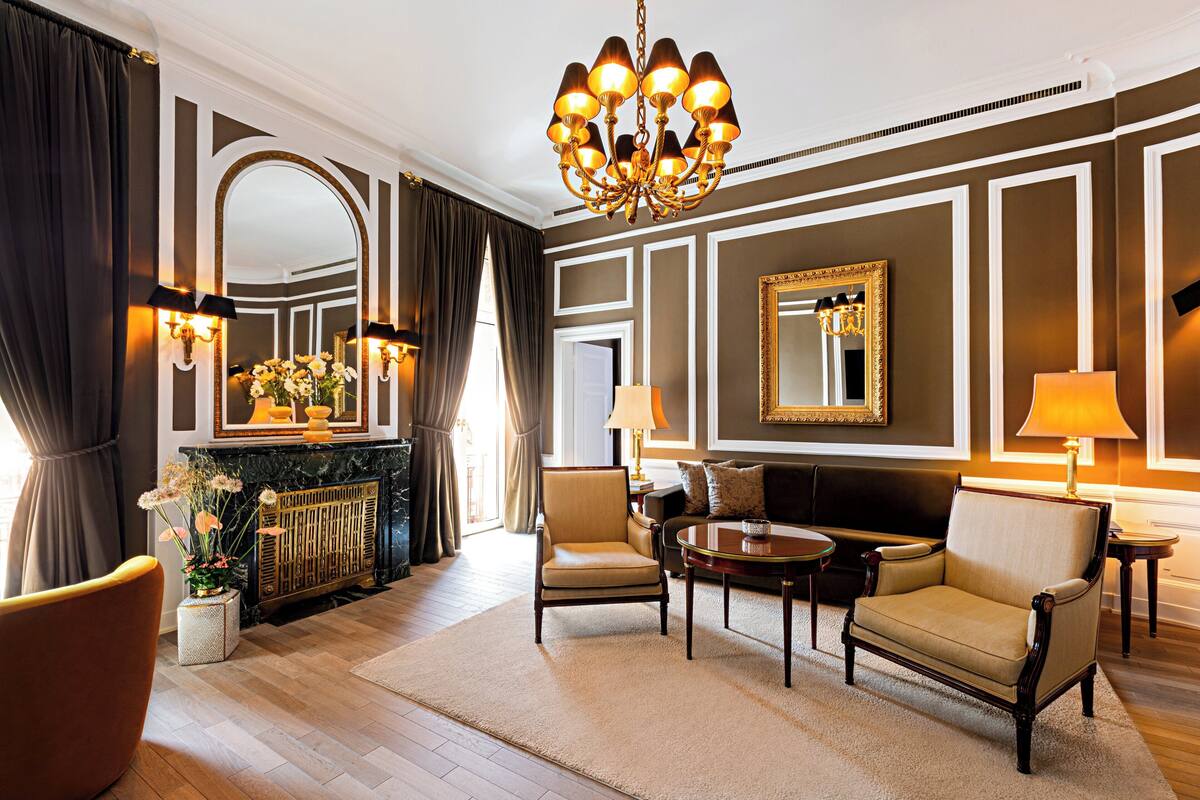 Uma sala de estar bem equipada, com lareira, assentos confortáveis e decoração elegante.