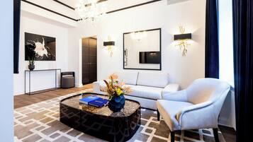 Ein modernes Wohnzimmer mit Sofa, Sesseln, Couchtisch und dekorativer Beleuchtung.